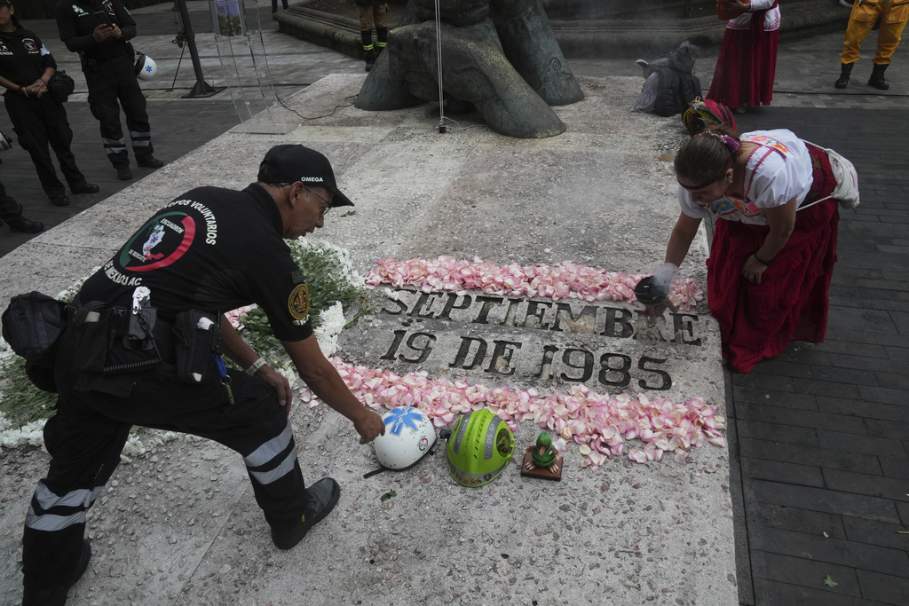 Francisco Camacho, of the Topos volunteer rescue workers brigade, left, and an Indigenous woman, attend a ceremony marking the 1985 earthquake's 40th anniversary in Mexico City, Friday, Sept. 19, 2025. (AP Photo/Marco Ugarte)