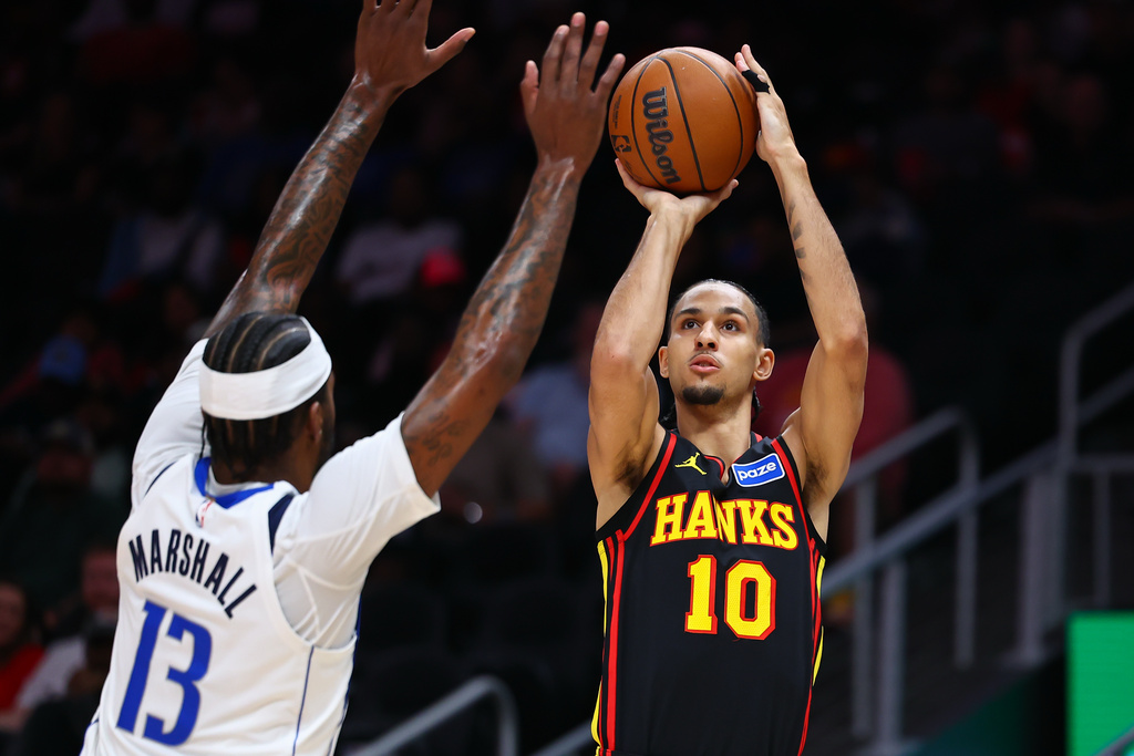 Atlanta Hawks forward Zaccharie Risacher (10) shoots against Dallas Mavericks forward Naji Marshall (13) during the first half of an NBA basketball game, Tuesday, March 10, 2026, in Atlanta. (AP Photo/Colin Hubbard)