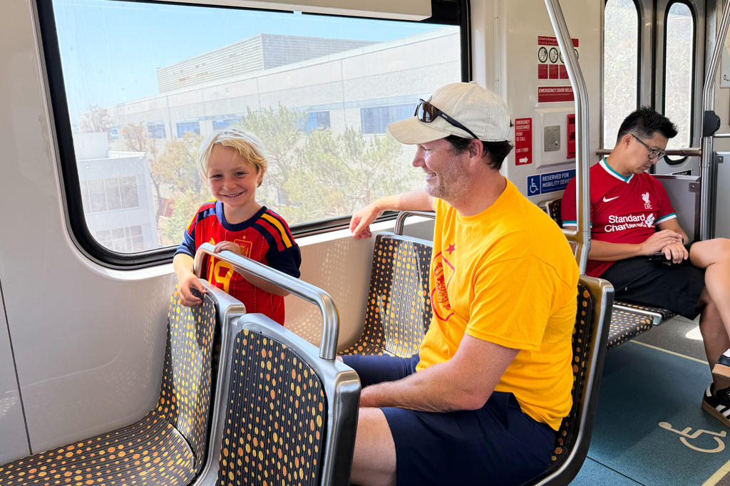 Matthew Smith and his son Whitacre, 5, ride the Metro after a World Cup match between Spain and Austria on Thursday, July 2, 2026, in Los Angeles. (AP Photo/Jaimie Ding)