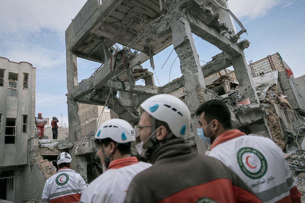 First responders inspect the remains of a residential building hit in an overnight strike during the U.S.-Israeli military campaign in Tabriz, East Azerbaijan Province, northwestern Iran, Tuesday, March 24, 2026. (AP Photo/Matin Hashemi)