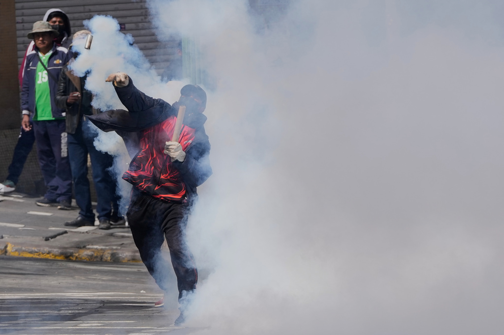 A protester returns a tear gas canister to police during an anti-government protest in La Paz, Bolivia, Monday, May 18, 2026. (AP Photo/Juan Karita)