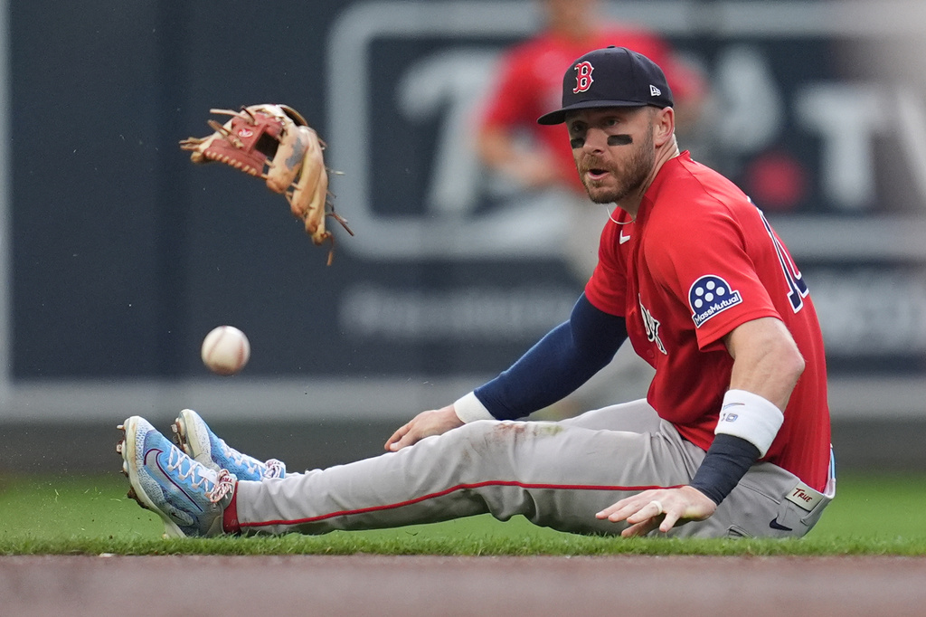 Boston Red Sox shortstop Trevor Story tries to field an infield single hit by Minnesota Twins' Brooks Lee during the first inning of a baseball game Monday, April 13, 2026, in Minneapolis. (AP Photo/Abbie Parr)
