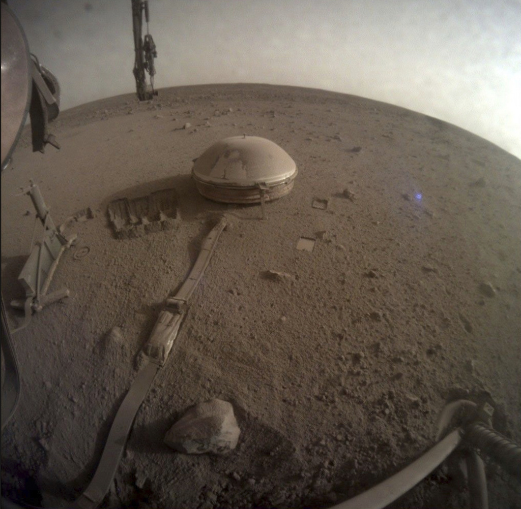 This image provided by NASA shows the seismometer on the surface of Mars attached to NASA's InSight lander, which registered more than 1,300 marsquakes before shutting down in 2022. This is one of the lander's last photos. (NASA via AP)
