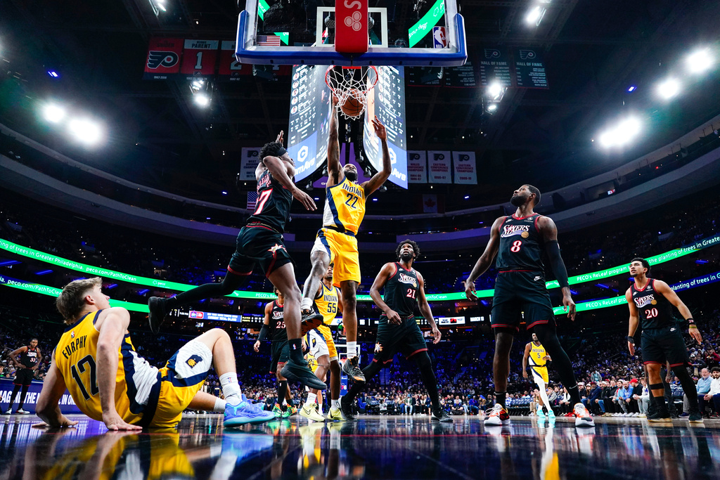 Indiana Pacers' Isaiah Jackson (22) puts back the shot that teammate Johnny Furphy, bottom left, missed with Philadelphia 76ers' VJ Edgecombe, top left, defending. during the first half of an NBA basketball game, Friday, Dec. 12, 2025, in Philadelphia. (AP Photo/Chris Szagola)