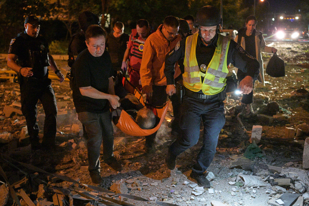 Emergency workers carry an injured person following Russian missile attacks in Kyiv, Ukraine, Monday, July 6, 2026. (AP Photo/Danylo Antoniuk)