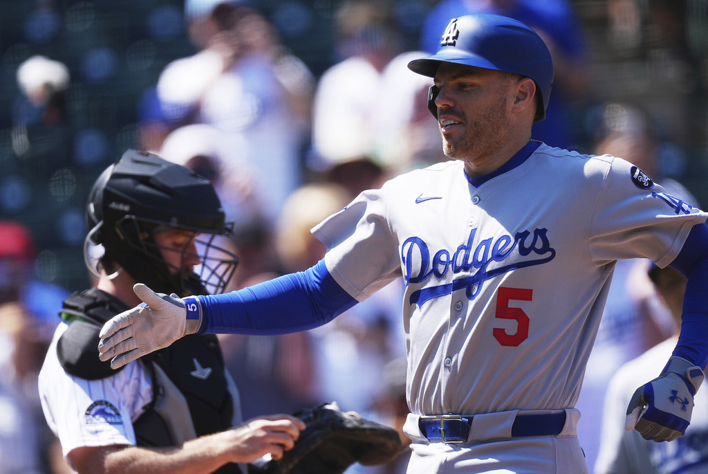 Los Angeles Dodgers' Freddie Freeman is congratulated as he crosses home plate after hitting a two-run home run off Colorado Rockies starting pitcher Chase Dollander in the first inning of a baseball game Thursday, Aug. 21, 2025, in Denver. (AP Photo/David Zalubowski)