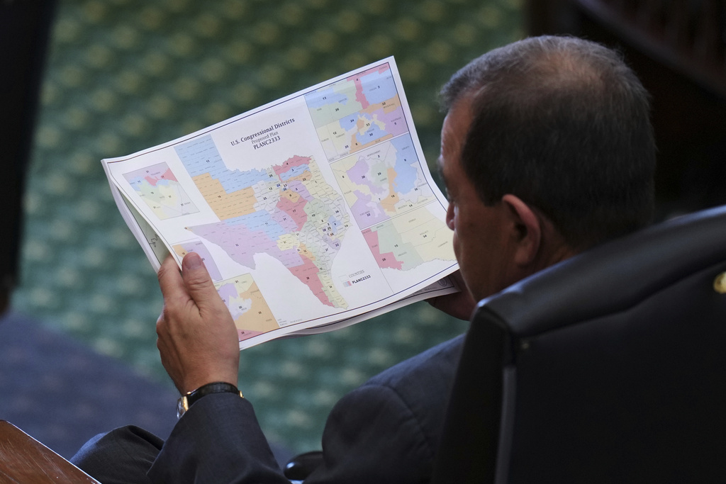 Texas state Sen. Pete Flores, R-Pleasanton, looks over a redrawn U.S. congressional map during debate over a bill in the Senate Chamber at the Texas Capitol in Austin, Texas, Friday, Aug. 22, 2025. (AP Photo/Eric Gay)