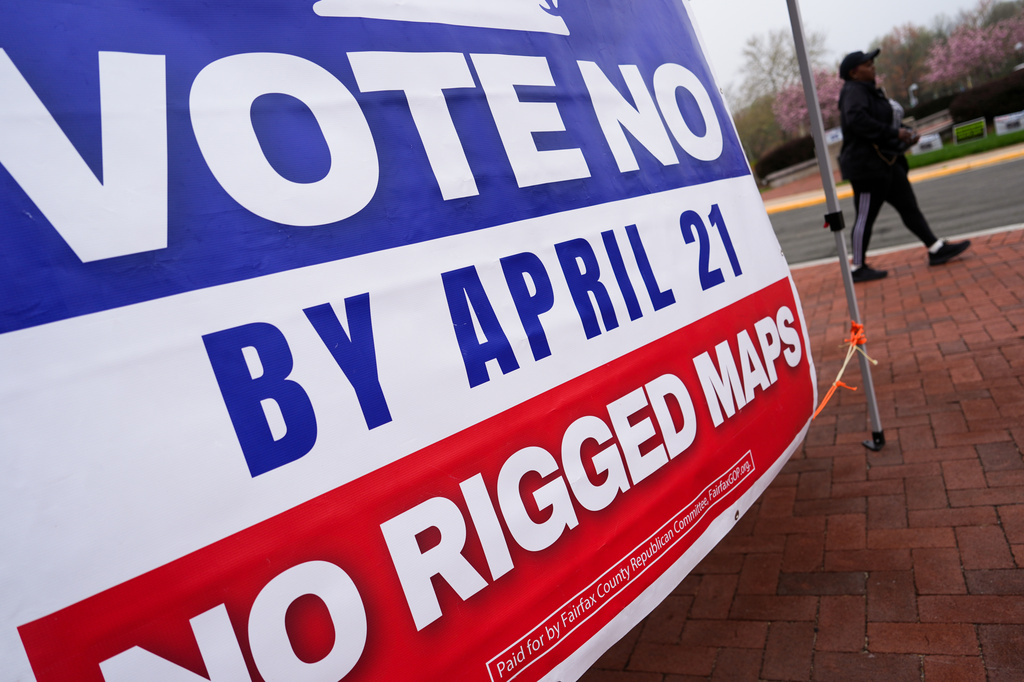 A voter walks past a sign opposing the Virginia redistricting referendum outside the Fairfax County Government Center during the early voting period Friday, April 3, 2026, in Fairfax, Va. (AP Photo/Julia Demaree Nikhinson)