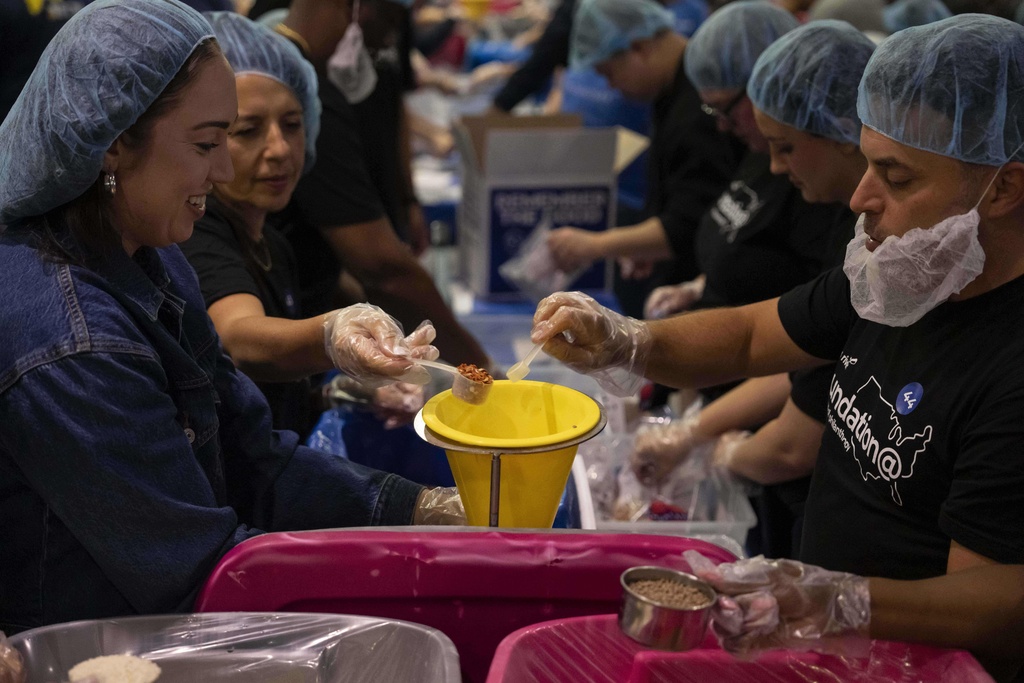 Volunteers work during the "NYC Meal Pack For 9/11 Day" at the Intrepid Sea, Air & Space Museum, Wednesday, Sep. 10, 2025, in New York. (AP Photo/Yuki Iwamura)
