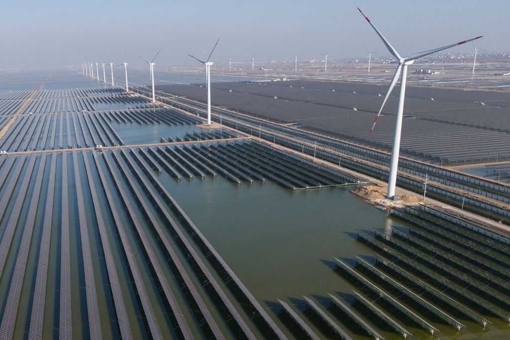 FILE - Wind turbines operate along a solar farm near Weifang in eastern China's Shandong province on March 22, 2024. (AP Photo/Ng Han Guan, File)