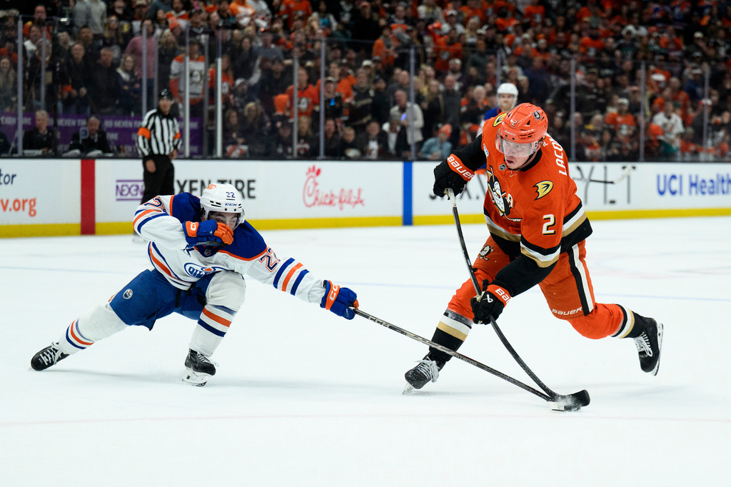 Edmonton Oilers center Matt Savoie, left, blocks the shot by Anaheim Ducks defenseman Jackson LaCombe during the third period of Game 4 in the first round of an NHL hockey Stanley Cup playoff series Sunday, April 26, 2026, in Anaheim, Calif. (AP Photo/Kyusung Gong)
