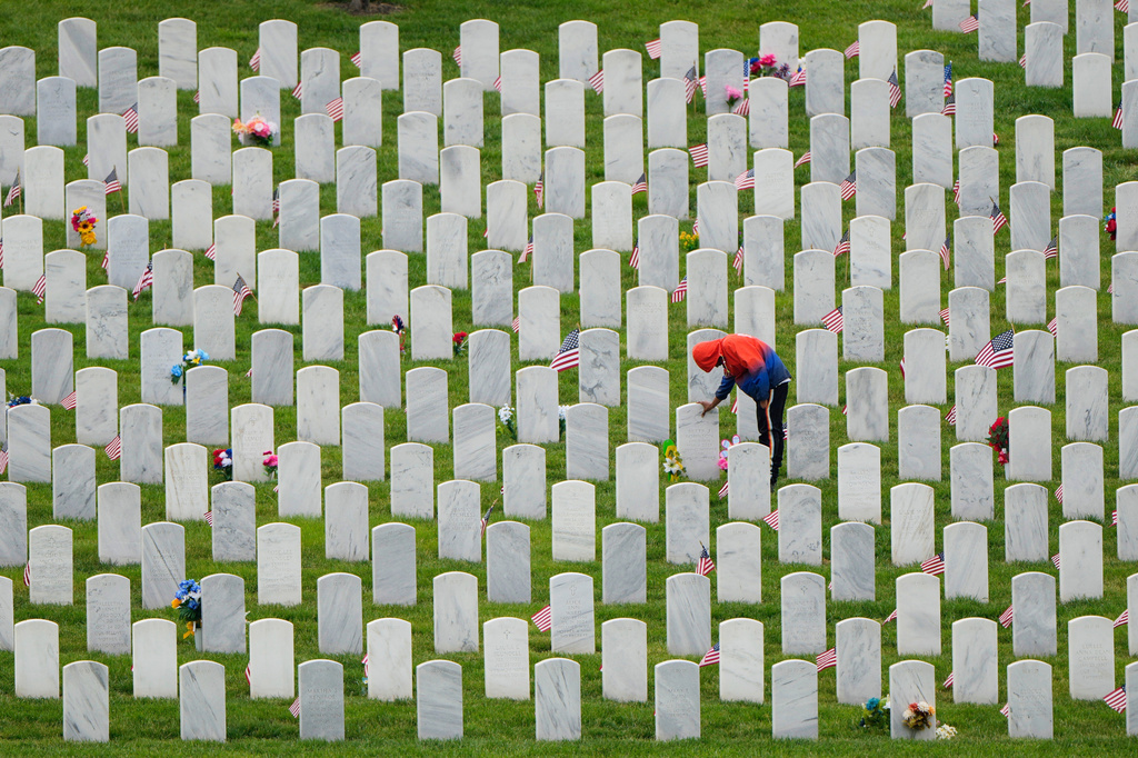 FILE - Richard Cross touches his grandmother's headstone while visiting Leavenworth National Cemetery on the eve of Memorial Day, Sunday, May 25, 2025, in Leavenworth, Kan. (AP Photo/Charlie Riedel, file)