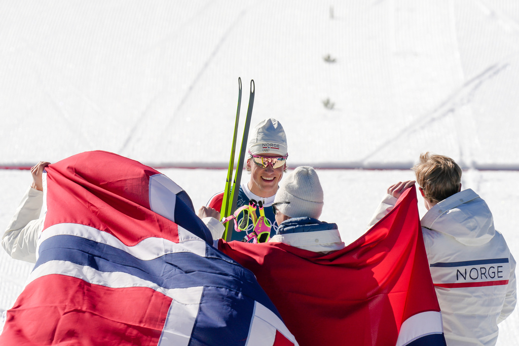 Johannes Hoesflot Klaebo, of Norway, center, joins his teammates Emil Iversen, Martin Loewstroem Nyenget and Einar Hedegart after crossing the finish line to win the gold medal in the cross country skiing men's 4 x 7.5km relay at the 2026 Winter Olympics, in Tesero, Italy, Sunday, Feb. 15, 2026. (AP Photo/Evgeniy Maloletka)