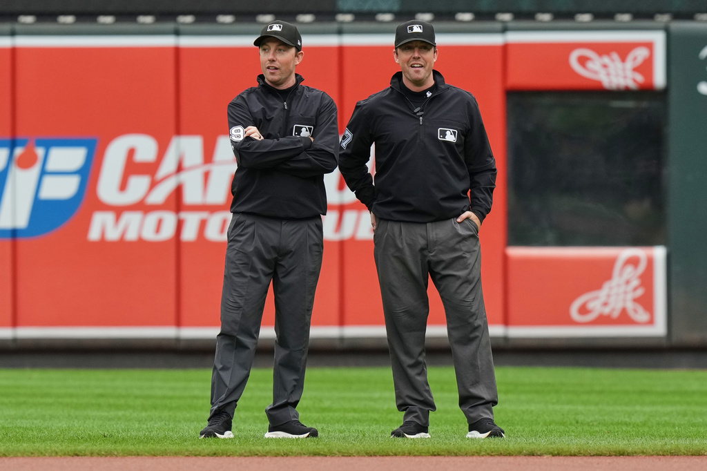 Second base umpire Tyler Jones, left, and his twin brother first base umpire Austin Jones talk before the first baseball game of a doubleheader between the Baltimore Orioles and the Toronto Blue Jays, Wednesday, Sept. 23, 2026, in Baltimore. (AP Photo/Stephanie Scarbrough)