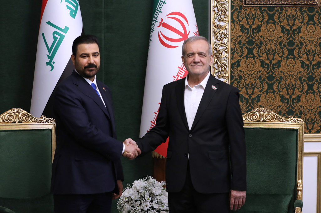 In this photo released by the Iranian Presidency Office, President Masoud Pezeshkian, right, shakes hands with Iraq's Prime Minister Ali al-Zaidi during their meeting in Tehran, Iran, Thursday, July 22, 2026. (Iranian Presidency Office via AP)