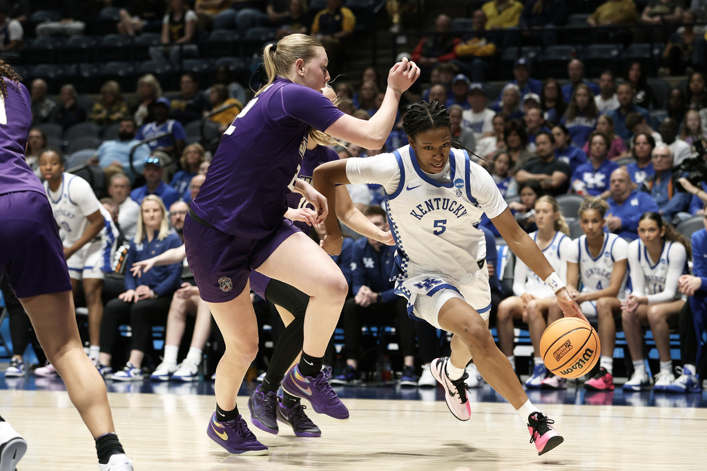 Kentucky guard Tonie Morgan (5) is defended by James Madison forward Grace McDonough (22) in the second half in the first round of the NCAA college basketball tournament, Saturday, March 21, 2026, in Morgantown, W.Va. (AP Photo/Kathleen Batten)