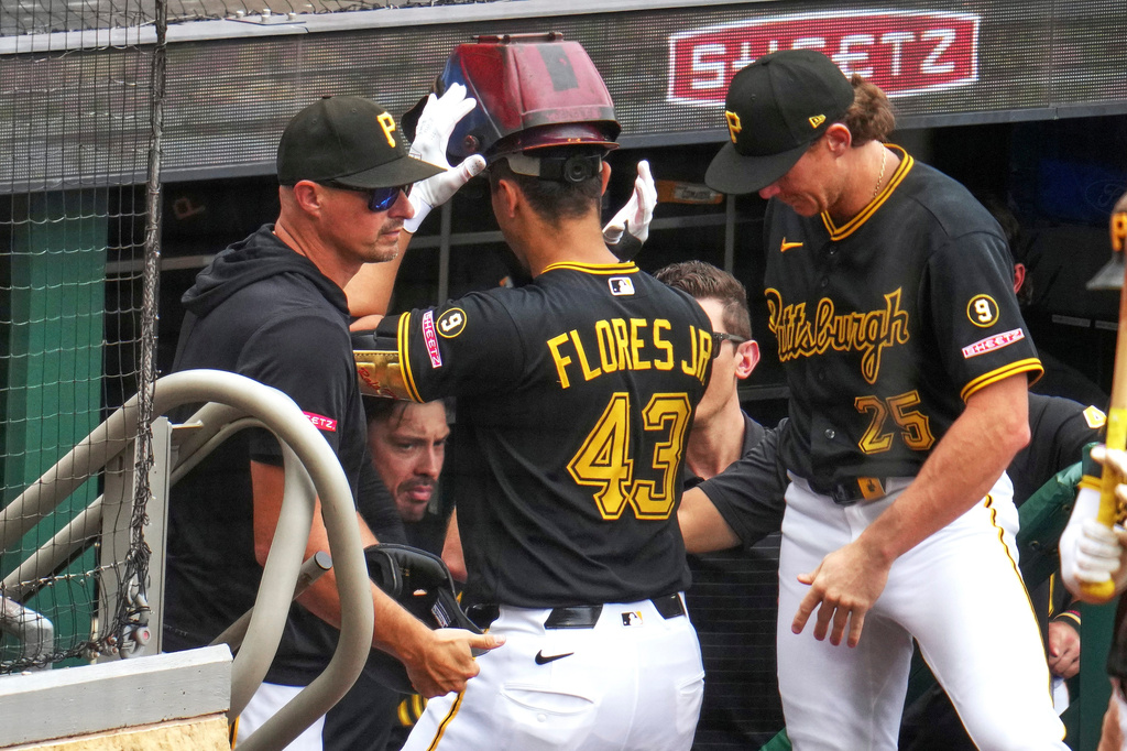 Pittsburgh Pirates' Rafael Flores Jr. (43) is met at the dugout steps by manager Don Kelly, left, and Billy Cook (25) after hitting a solo home run off Detroit Tigers pitcher Jacob Waguespack during the seventh inning of a baseball game in Pittsburgh, Wednesday, Aug. 19, 2026. (AP Photo/Gene J. Puskar)