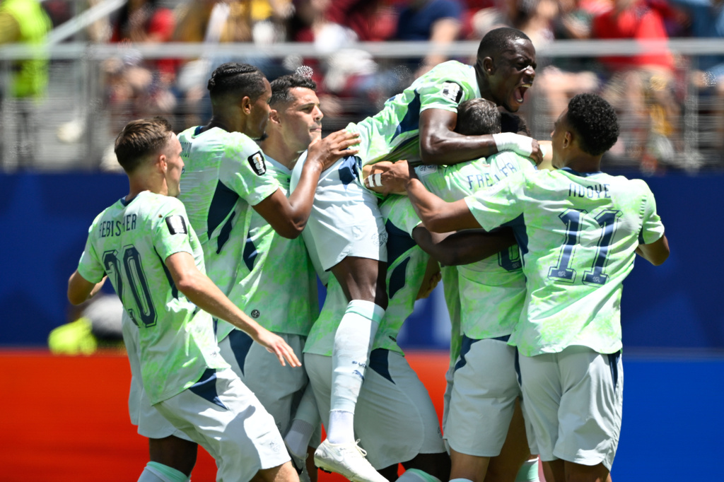 Switzerland's Breel Embolo is mobbed by teammates after scoring the opening goal from the penalty spot during the World Cup Group B soccer match between Qatar and Switzerland in Santa Clara, Calif., near San Francisco, Saturday, June 13, 2026. (AP Photo/Eakin Howard)