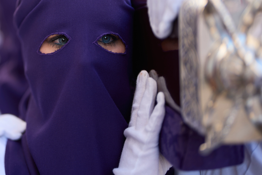 A hooded penitent of the Nuestro Padre Jesus del Huerto y San Diego brotherhood participates in a Holy Week procession in Baena, southern Spain, Wednesday, April 1, 2026. (AP Photo/Manu Fernandez)