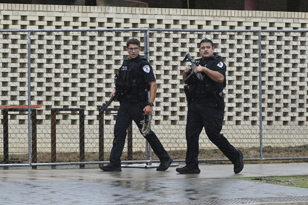 Law enforcement officers respond to reports of a shooting on the University of Arkansas campus Monday, Aug. 25, 2025, in Fayetteville, Ark. (AP Photo/Michael Woods)