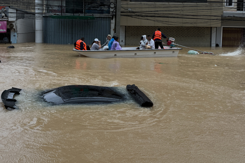 Thai rescue crew on boat move past a car submerged in floodwaters in Songkhla province, southern Thailand, Monday, Nov. 24, 2025. (AP Photo)
