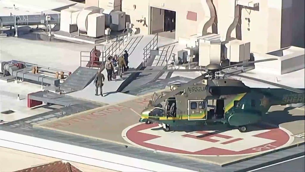 Individuals are stretchered off after a police helicopter lands on helipad on Monday, Dec. 29, 2025 in San Bernardino, Calif. (ABC7 Los Angeles via AP)