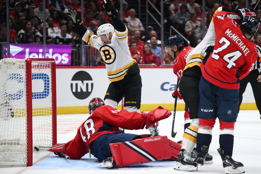 Boston Bruins center Morgan Geekie, top, celebrates a goal by teammate David Pastrnak, not seen, against Washington Capitals goaltender Logan Thompson (48) during the second period of an NHL hockey game, Wednesday, Oct. 8, 2025, in Washington. (AP Photo/Nick Wass)