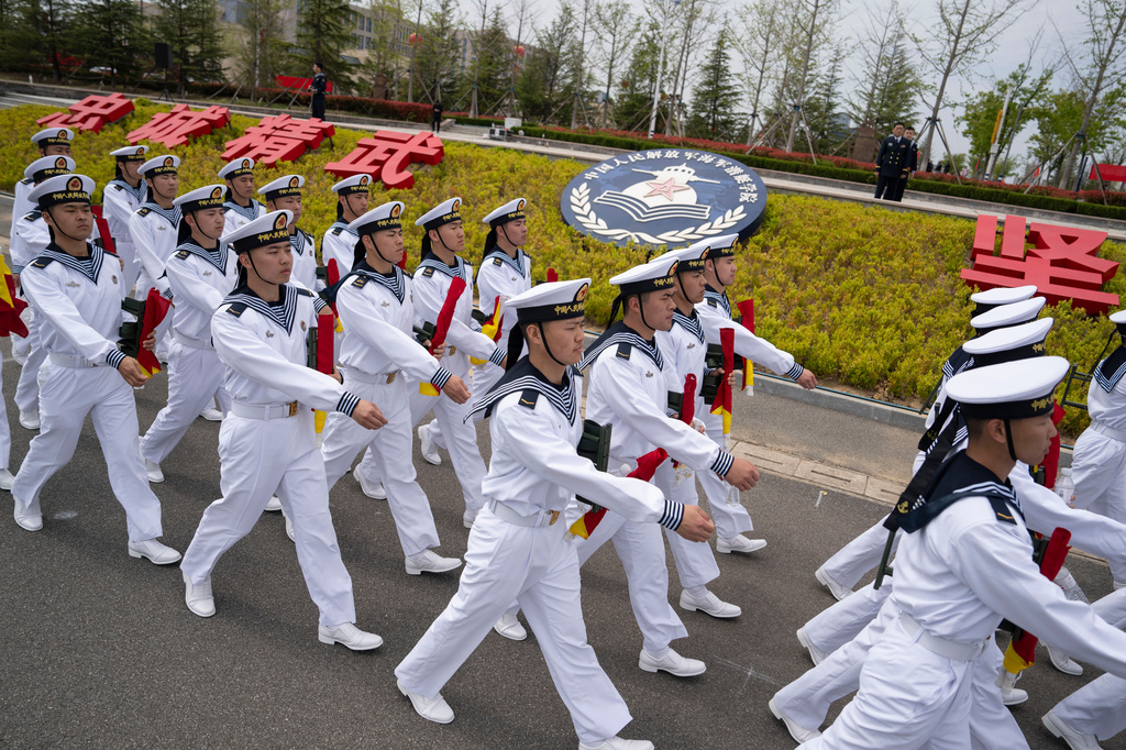 FILE - Sailors march past the insignia for the People's Liberation Army (PLA)'s naval submarine academy during a tour arranged for foreign journalists a day before the opening of the West Pacific Naval Symposium in Qingdao in eastern China's Shandong province, Sunday, April 21, 2024. (AP Photo/Ng Han Guan, File)