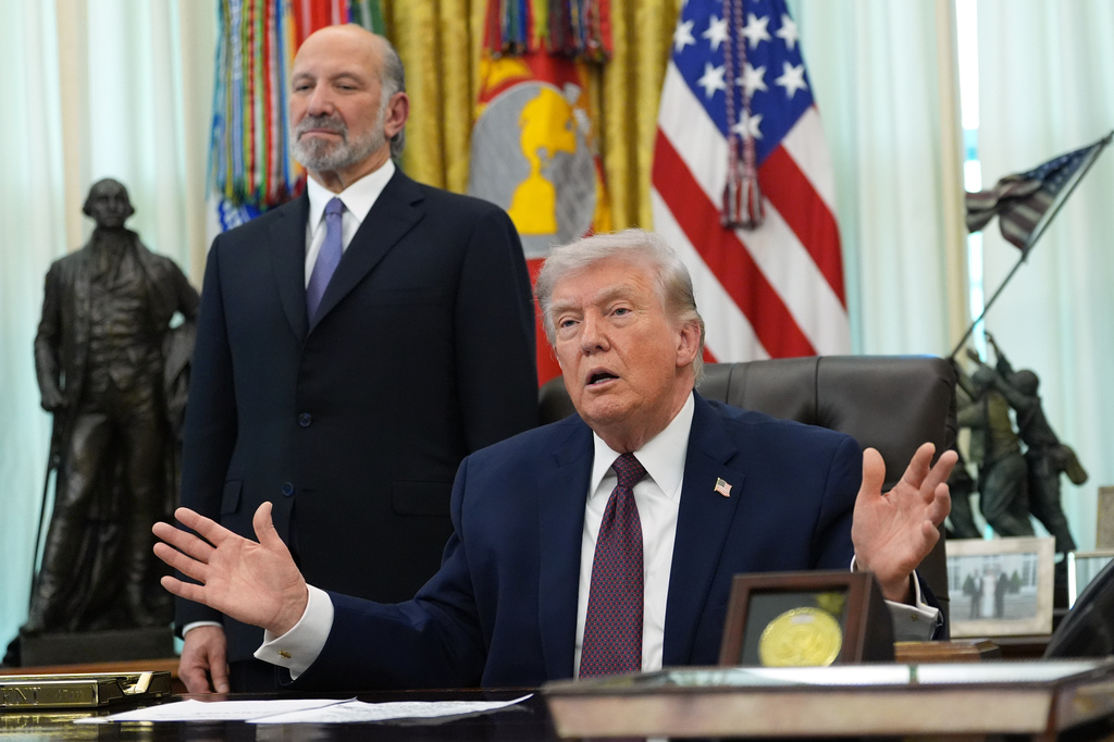 President Donald Trump answers questions from reporters after signing an executive order in the Oval Office of the White House Tuesday, March 31, 2026, in Washington, as Commerce Secretary Howard Lutnick listens. (AP Photo/Alex Brandon)