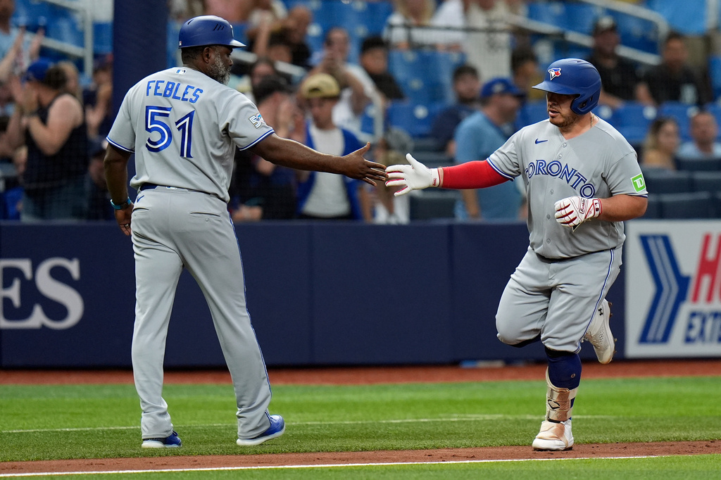 Toronto Blue Jays' Alejandro Kirk celebrates his home run off Tampa Bay Rays pitcher Drew Rasmussen with third base coach Carlos Febles (51) during the fourth inning of a baseball game Wednesday, Aug. 19, 2026, in St. Petersburg, Fla. (AP Photo/Chris O'Meara)