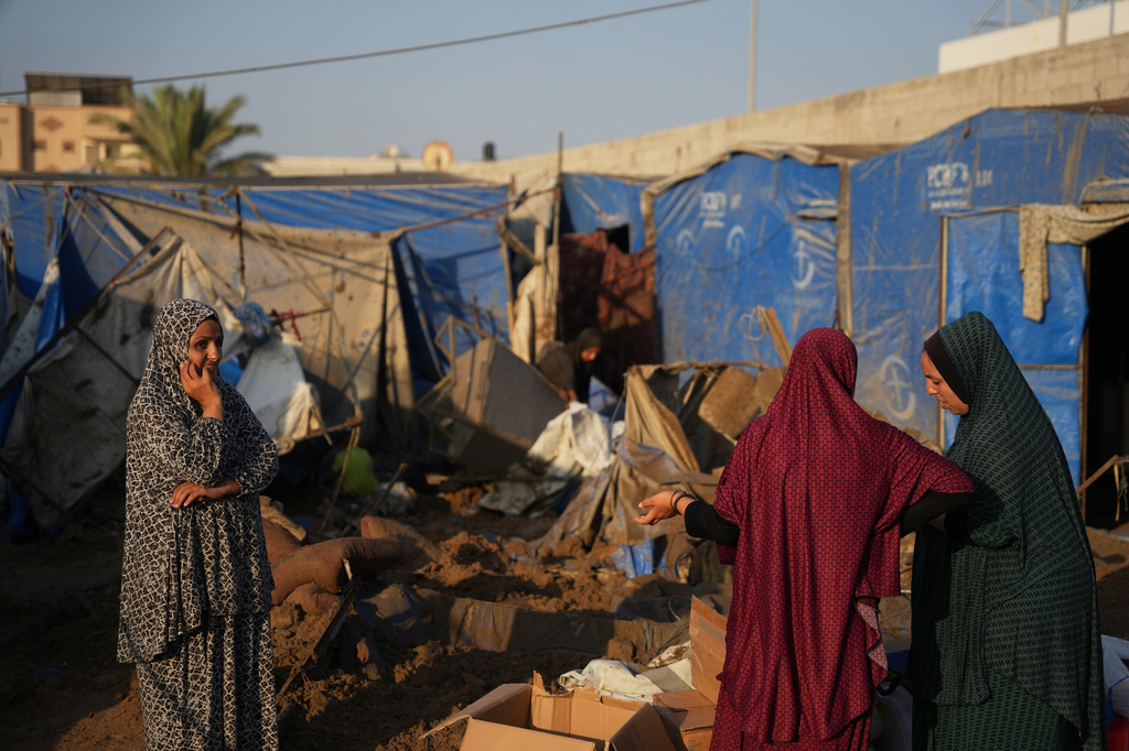 Palestinian women inspect the scene of an Israeli airstrike near al-Aqsa Hospital in Deir al-Balah in the central Gaza Strip, Saturday, Aug. 1, 2026. (AP Photo/Abdel Kareem Hana)