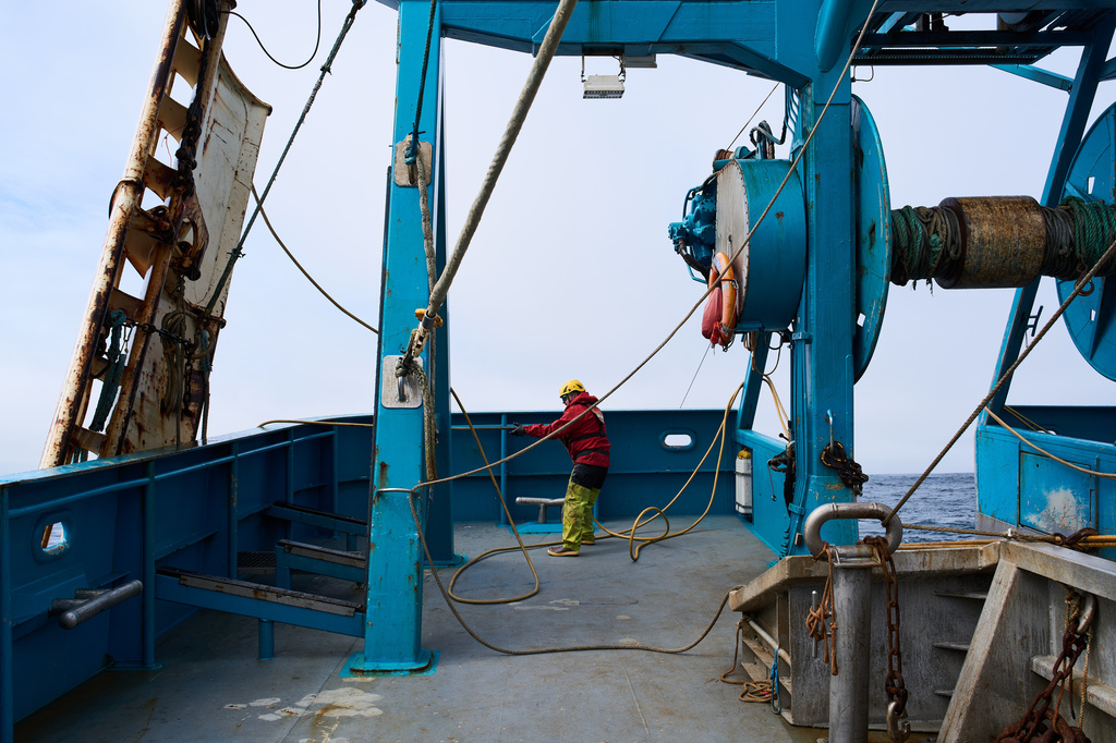 Deckhand Justin Schramm lifts trawl doors, which help spread the mouth of the net open, from the Bering Sea off the coast of Alaska, Thursday, July 23, 2026. (AP Photo/Annika Hammerschlag)