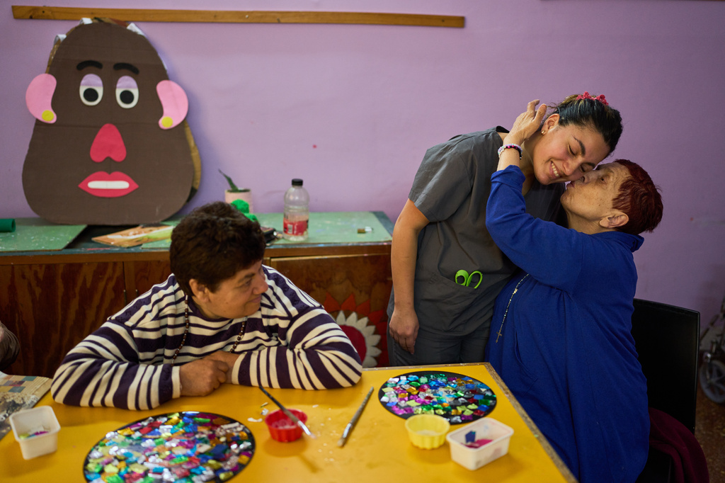 Stella Maris Fernandez kisses instructor Lucia Carrera while taking part in an art workshop at the Pequeño Cottolengo Don Orione, a home for people with disabilities that will be visited by Pope Leo XIV in November, in Buenos Aires, Argentina, Thursday, Sept. 24, 2026. (AP Photo/Rodrigo Abd)