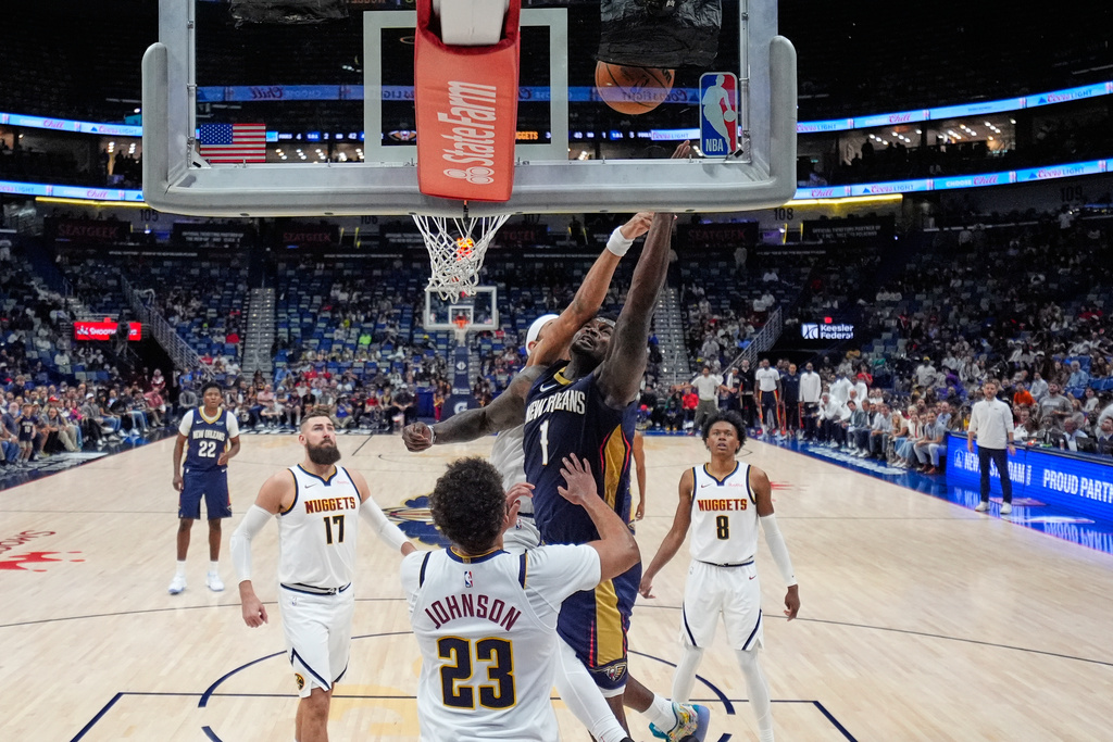 New Orleans Pelicans forward Zion Williamson (1) goes to the basket in front of Denver Nuggets forward Cameron Johnson (23) in the second half of an NBA basketball game, Wednesday, Nov. 19, 2025, in New Orleans. (AP Photo/Gerald Herbert)