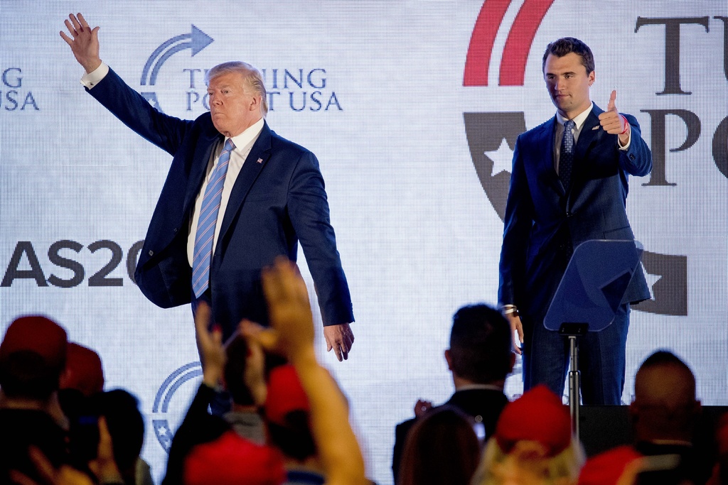 FILE - President Donald Trump is joined on stage with Turning Point USA Founder Charlie Kirk as he finishes speaking at the Marriott Marquis in Washington, July 23, 2019. (AP Photo/Andrew Harnik, File)