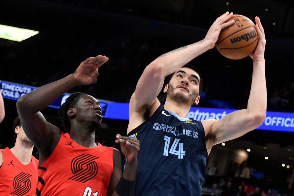 Memphis Grizzlies center Zach Edey (14) handles the ball against Portland Trail Blazers guard Sidy Cissoko (91) in the first half of an NBA basketball game Sunday, Dec. 7, 2025, in Memphis, Tenn. (AP Photo/Brandon Dill)