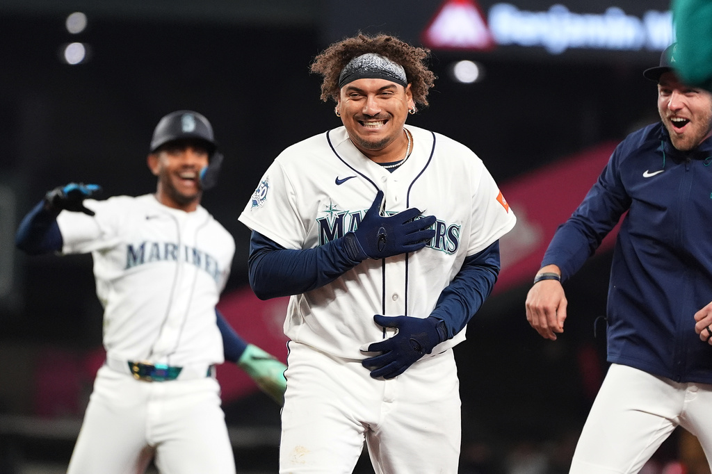 Seattle Mariners' Josh Naylor, center, celebrates with Julio Rodríguez, left, and Luke Raley, right, after hitting a game-winning single against the Athletics during the ninth inning of a baseball game, Wednesday, April 22, 2026, in Seattle. (AP Photo/Lindsey Wasson)
