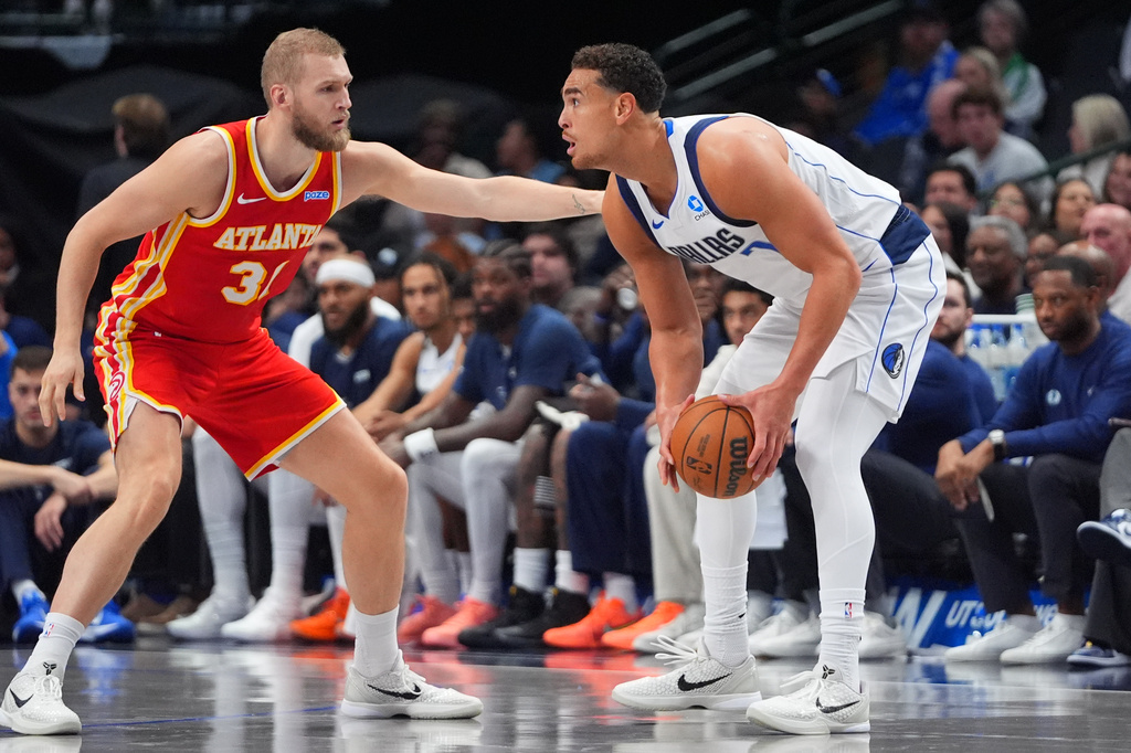 Dallas Mavericks forward Dwight Powell, right, looks to move the ball against Atlanta Hawks center Jock Landale, left, during the first half of a preseason NBA basketball game in Dallas, Friday, Oct. 16, 2026. (AP Photo/LM Otero)