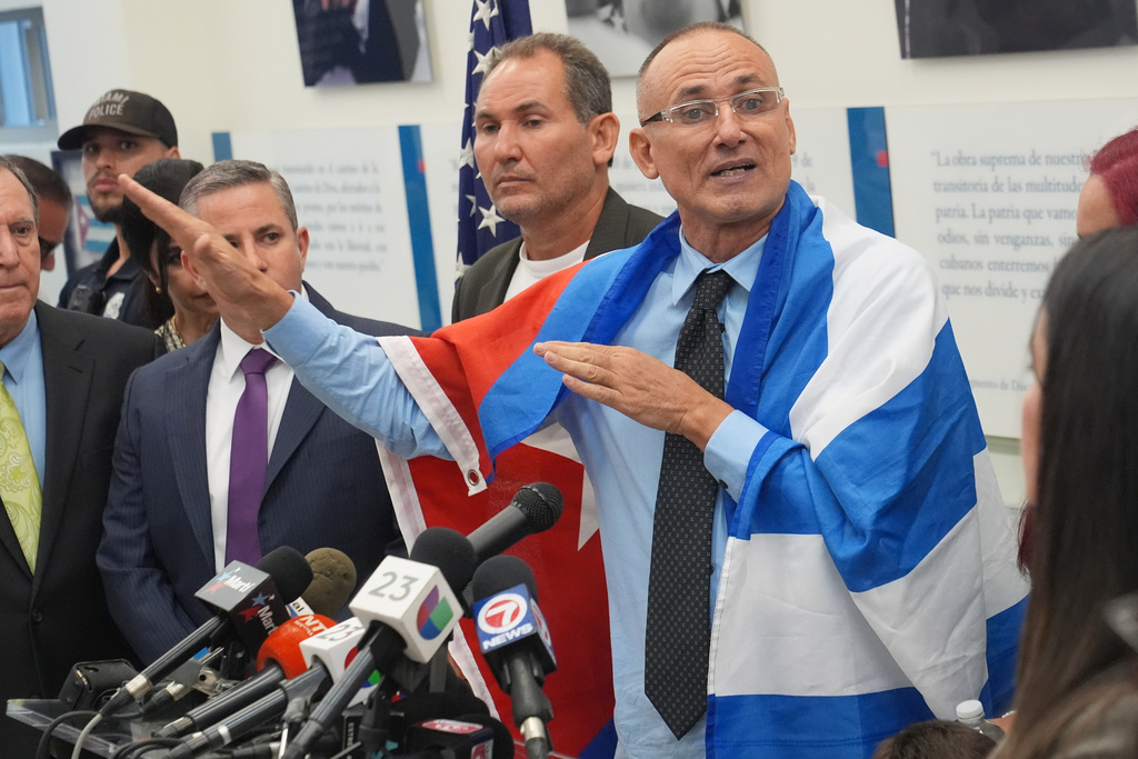 Cuban dissident Jose Daniel Ferrer, wearing his nation's flag over his shoulders, gives a news conference in Miami, Florida, Monday, Oct. 13, 2025, the day he left Cuba for exile in the U.S. (AP Photo/Marta Lavandier)