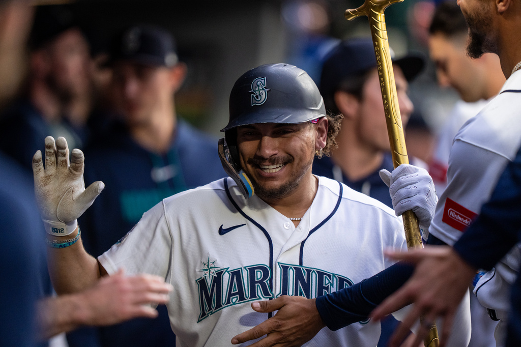 Seattle Mariners' Josh Naylor celebrates in the dugout after hitting a solo home run during the seventh inning of a baseball game against the New York Mets, Monday, June 1, 2026, in Seattle. (AP Photo/Stephen Brashear)