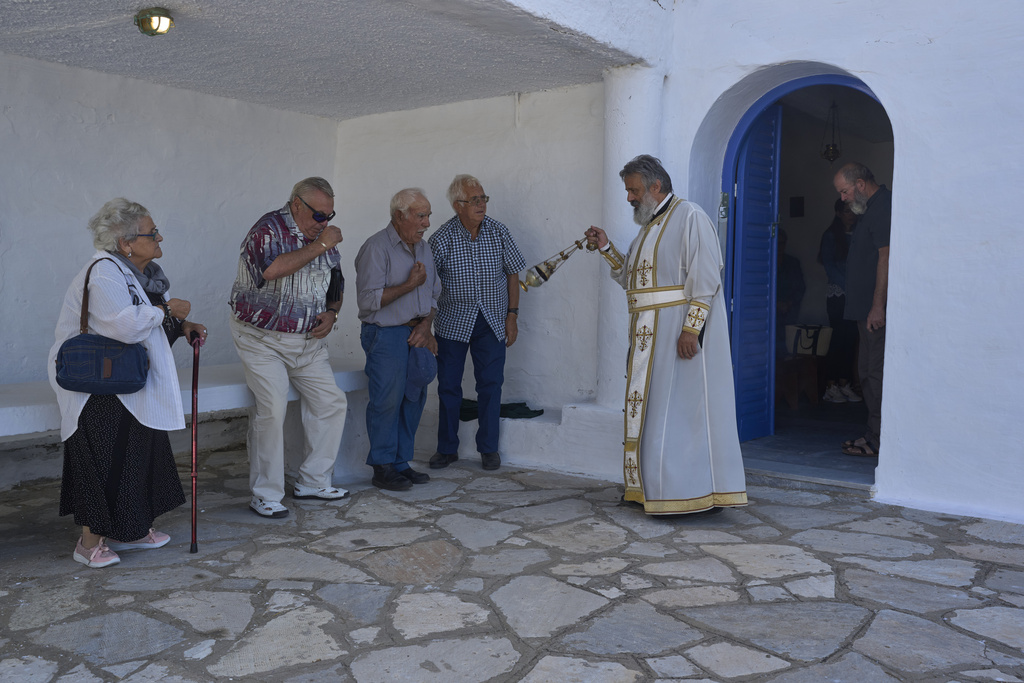 An Orthodox priest swings a censer during a liturgy at the family-owned Agios Sostis chapel on the island of Tinos, Greece, Monday, Sept. 8, 2025. (AP Photo/Petros Giannakouris)
