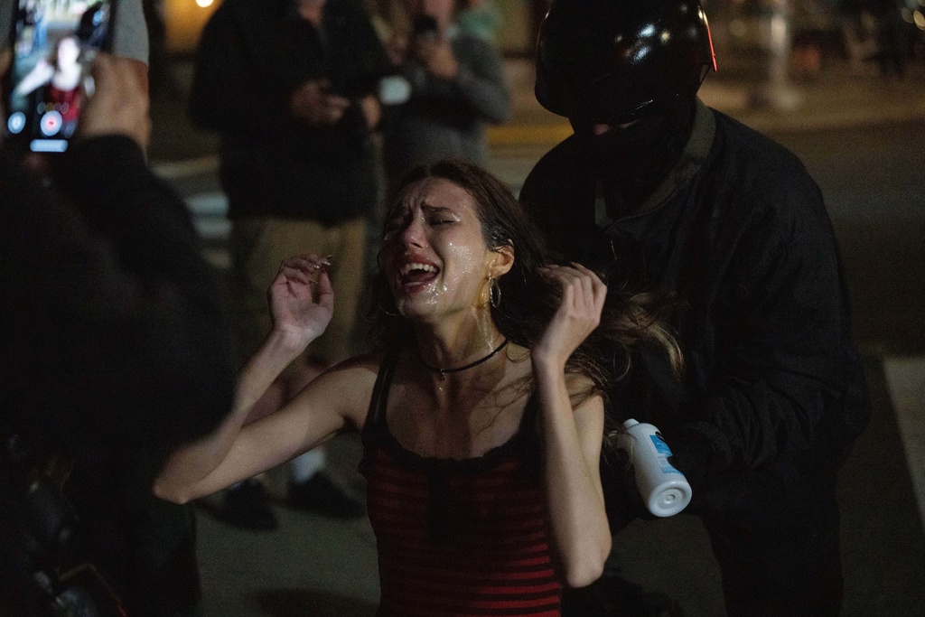 A protestor reacts after getting sprayed by Department of Homeland Security officers outside a U.S. Immigration and Customs Enforcement facility on Thursday, Oct. 2, 2025, in Portland, Ore. (AP Photo/Jenny Kane)