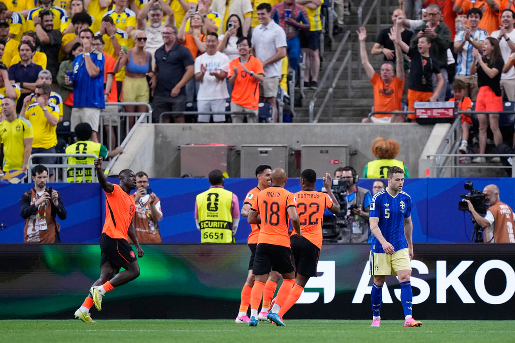 Sweden's Gabriel Gudmundsson, right, reacts as Netherlands' Brian Brobbey, left, celebrates after scoring his side's second goal during the World Cup Group F soccer match between the Netherlands and Sweden in Houston, Saturday, June 20, 2026. (AP Photo/Ashley Landis)