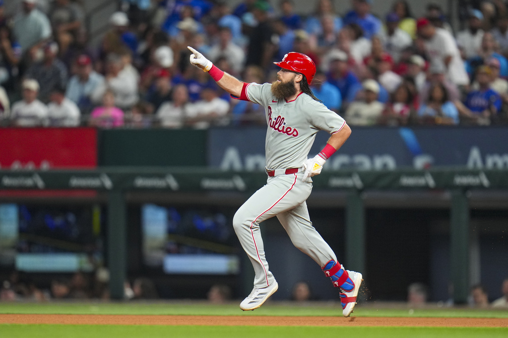Philadelphia Phillies' Brandon Marsh reacts while running the bases after hitting a solo home run off Texas Rangers pitcher Merrill Kelly during the fourth inning of a baseball game Friday, Aug. 8, 2025, in Arlington, Texas. (AP Photo/Julio Cortez)