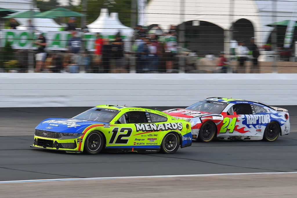 Ryan Blaney (12) and William Byron (24) steer their cars out of Turn 4 during a NASCAR Cup Series auto race, Sunday, Aug. 23, 2026, at New Hampshire Motor Speedway in Loudon, N.H. (AP Photo/Steven Senne)