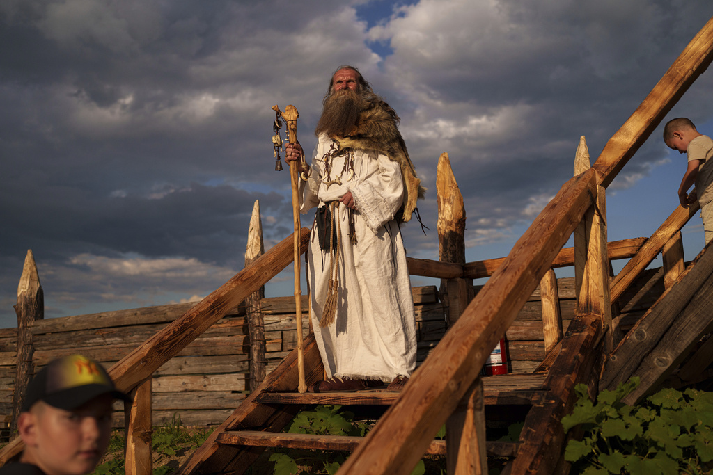 A man wearing a Dacian spiritual leader outfit stands on the steps of a Getic fortress replica in Poiana, Romania, Saturday, July 12, 2025 during the Getodava historical reenactment festival. (AP Photo/Vadim Ghirda)