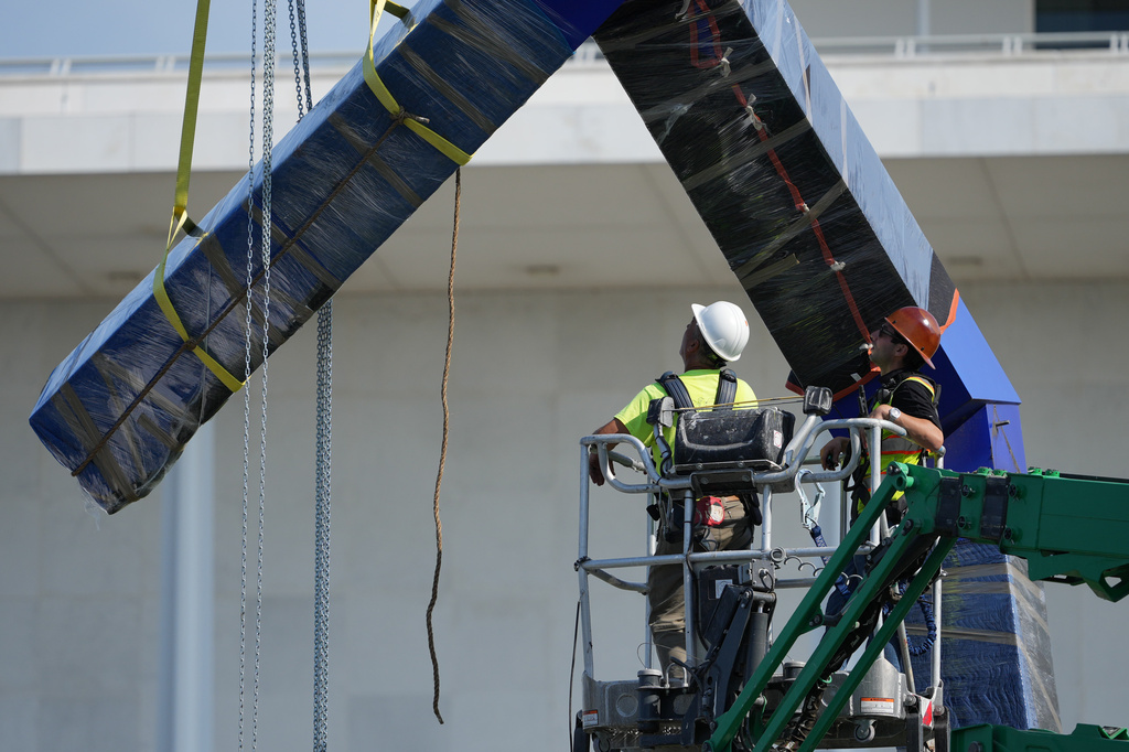 Workers remove the sculpture "Blue" by artist Joel Shapiro on the grounds of the John F. Kennedy Center for the Performing Arts in Washington, Wednesday, Sept. 2, 2026. (AP Photo/Mark Schiefelbein)