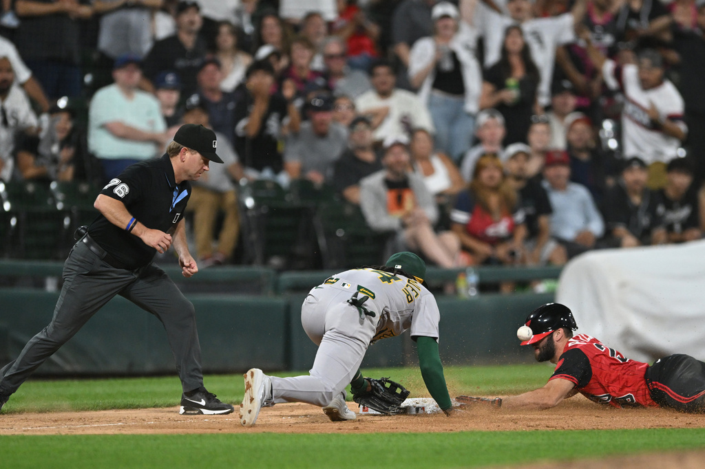 Chicago White Sox's Tristan Peters, right, slides safely into third base for an RBI triple while the Athletics third baseman Joshua Kuroda-Grauer, left, catches the throw during the seventh inning of a baseball game in Chicago, Friday, July 10, 2026. (AP Photo/Paul Beaty)