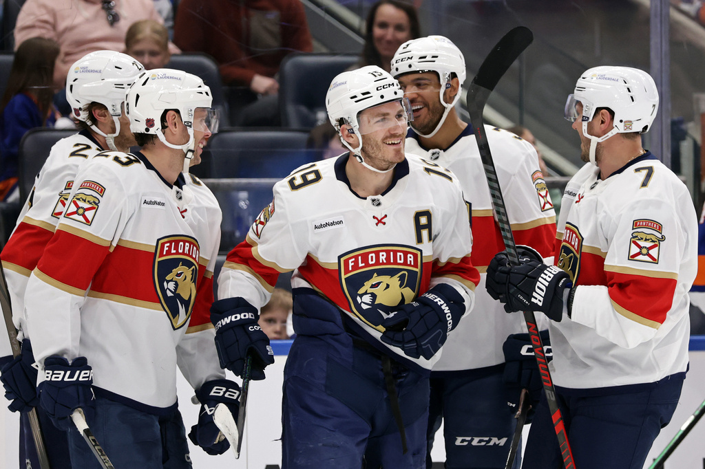Florida Panthers left wing Matthew Tkachuk (19) is congratulated by teammates after scoring his second goal in the first period an NHL hockey game against the New York Islanders, Saturday, March 28, 2026, in Elmont, N.Y. (AP Photo/Adam Hunger)