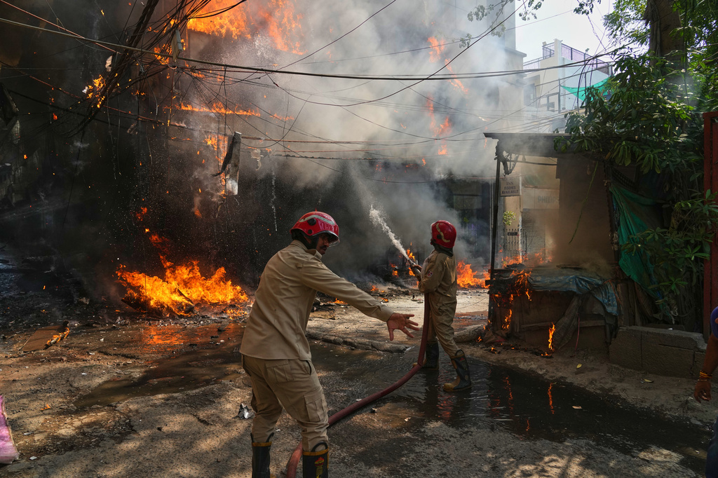 Firefighters douse a fire in a hotel in New Delhi, India, Wednesday, June 3, 2026. (AP Photo/Manish Swarup)